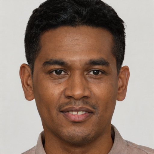 Joyful latino young-adult male with short  black hair and brown eyes