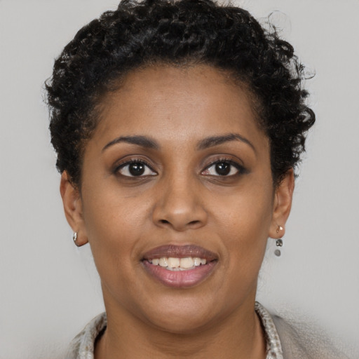 Joyful black young-adult female with short  brown hair and brown eyes