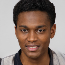 Joyful black young-adult male with short  brown hair and brown eyes