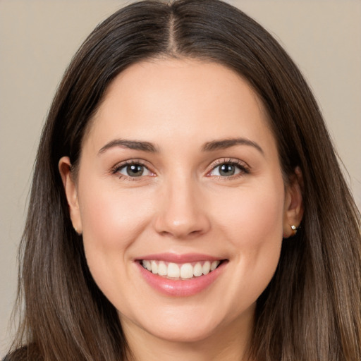 Joyful white young-adult female with long  brown hair and brown eyes