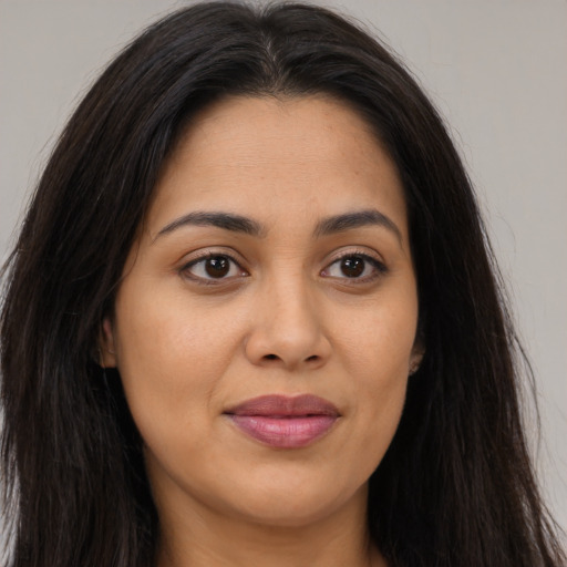 Joyful latino young-adult female with long  brown hair and brown eyes