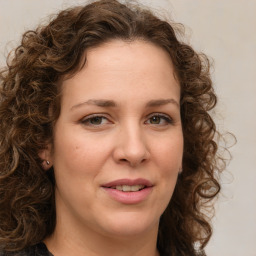 Joyful white young-adult female with medium  brown hair and green eyes