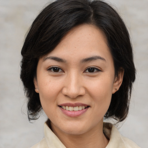 Joyful asian young-adult female with medium  brown hair and brown eyes