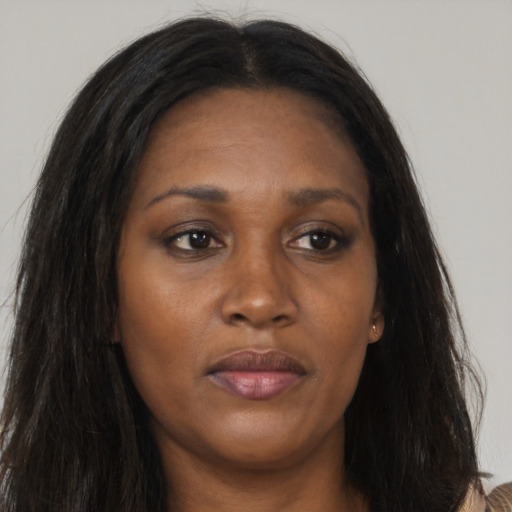 Joyful black adult female with long  brown hair and brown eyes