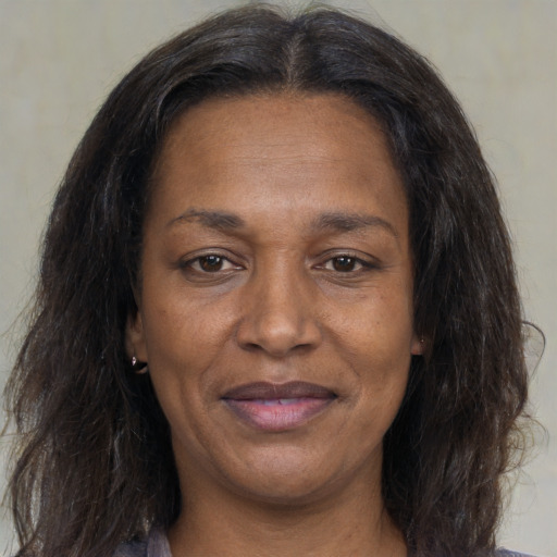 Joyful black adult female with medium  brown hair and brown eyes