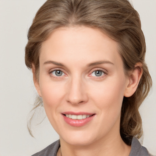 Joyful white young-adult female with medium  brown hair and grey eyes