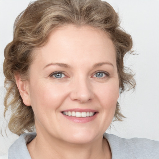 Joyful white young-adult female with medium  brown hair and blue eyes