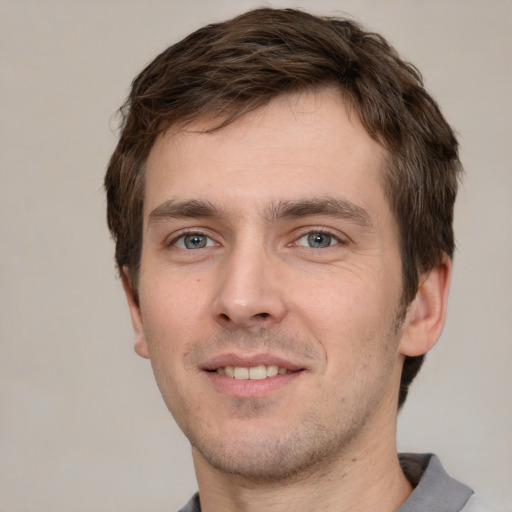 Joyful white young-adult male with short  brown hair and grey eyes