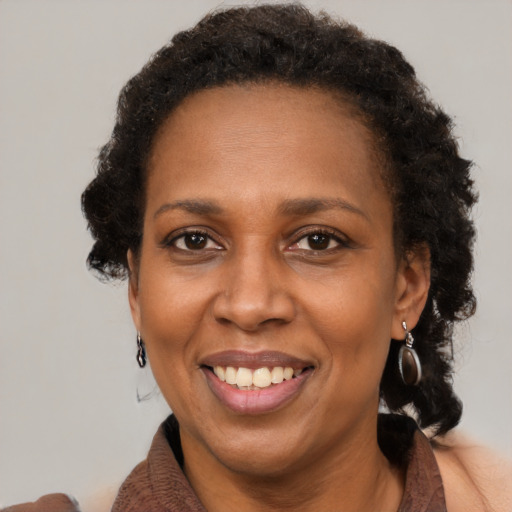 Joyful black adult female with medium  brown hair and brown eyes