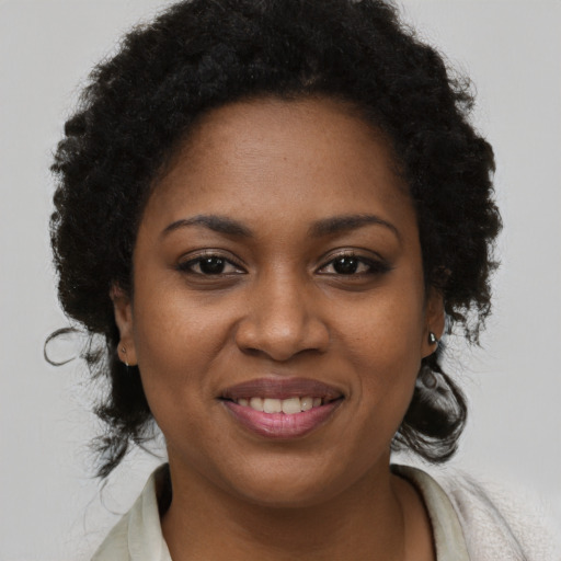 Joyful black young-adult female with long  brown hair and brown eyes