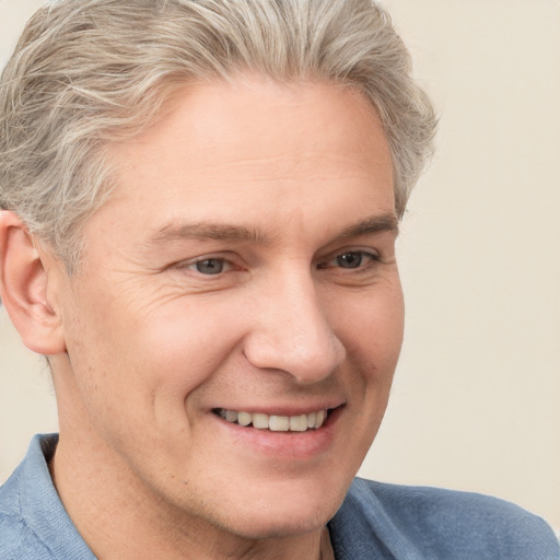 Joyful white adult male with short  brown hair and blue eyes