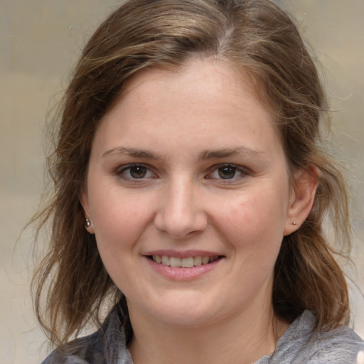 Joyful white young-adult female with medium  brown hair and grey eyes