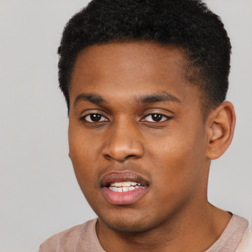 Joyful black young-adult male with short  black hair and brown eyes