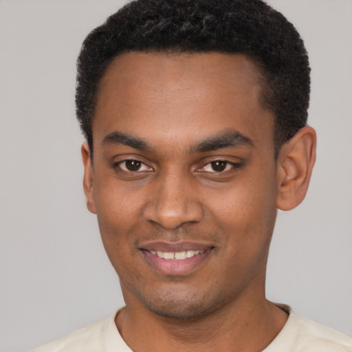 Joyful black young-adult male with short  black hair and brown eyes