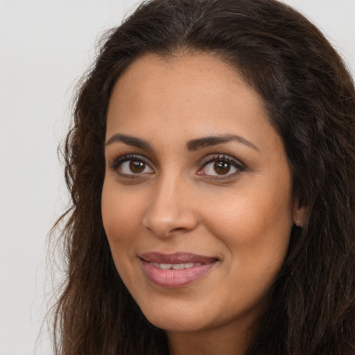 Joyful latino young-adult female with long  brown hair and brown eyes
