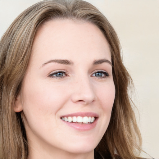 Joyful white young-adult female with long  brown hair and blue eyes