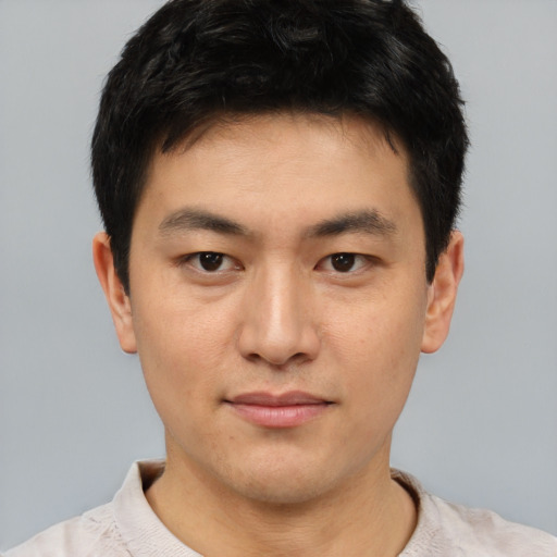 Joyful asian young-adult male with short  brown hair and brown eyes
