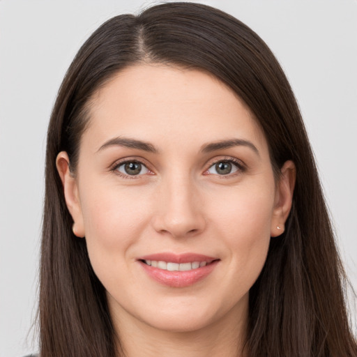 Joyful white young-adult female with long  brown hair and brown eyes