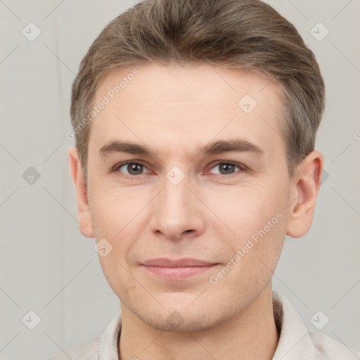 Joyful white young-adult male with short  brown hair and grey eyes