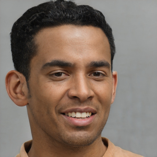 Joyful latino young-adult male with short  brown hair and brown eyes