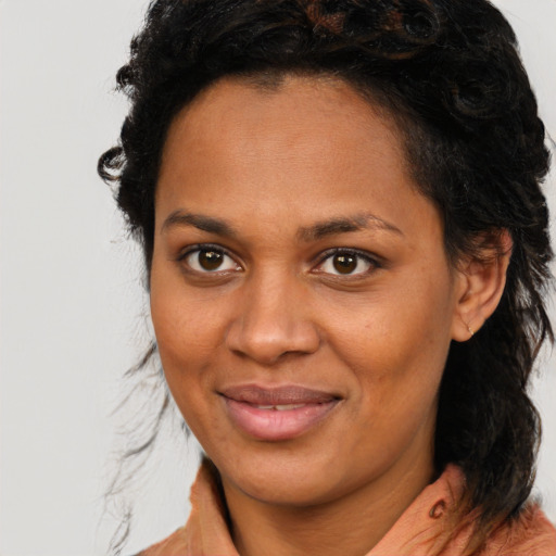 Joyful black young-adult female with medium  brown hair and brown eyes