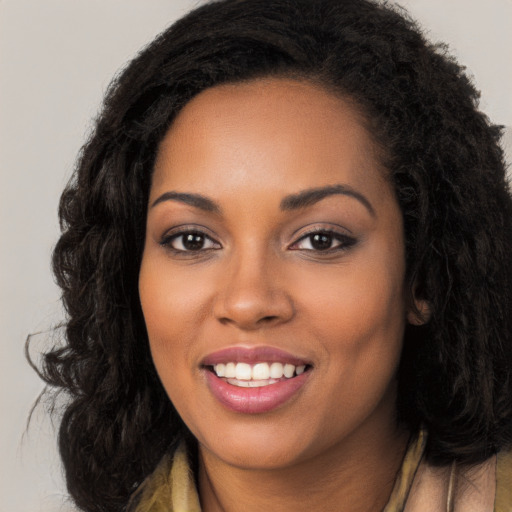 Joyful black young-adult female with long  brown hair and brown eyes