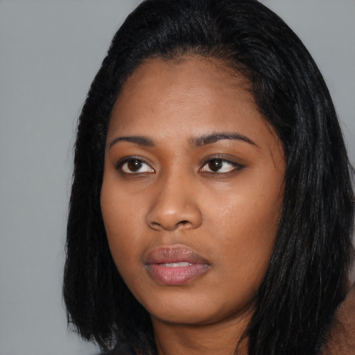 Joyful black young-adult female with long  black hair and brown eyes