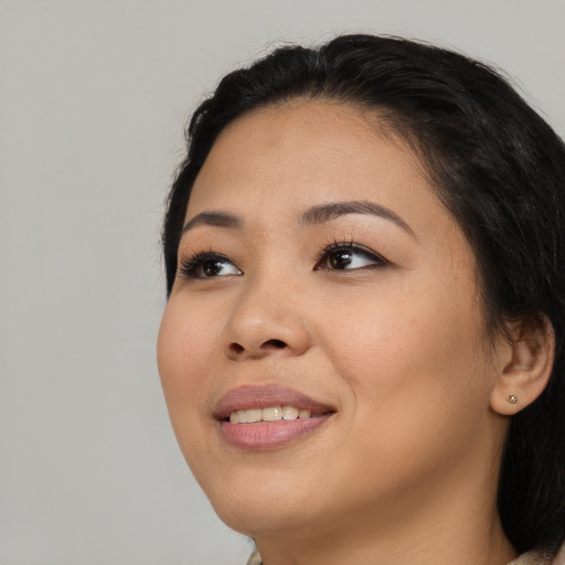 Joyful asian young-adult female with long  brown hair and brown eyes