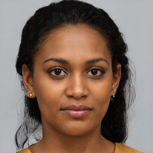 Joyful black young-adult female with long  brown hair and brown eyes