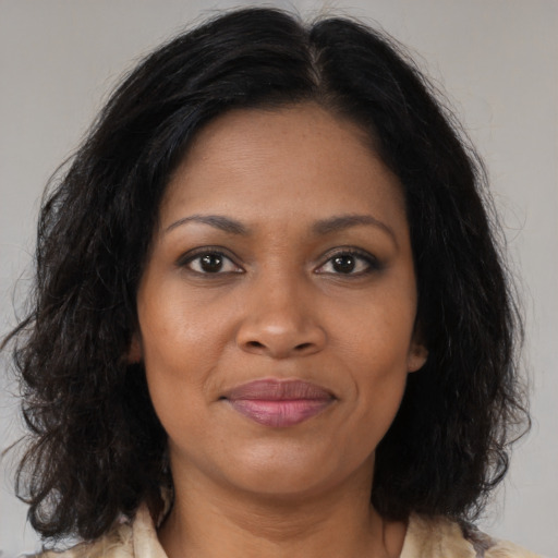 Joyful black adult female with medium  brown hair and brown eyes