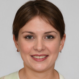 Joyful white young-adult female with medium  brown hair and grey eyes