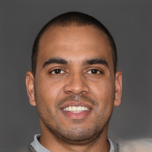 Joyful black young-adult male with short  brown hair and brown eyes