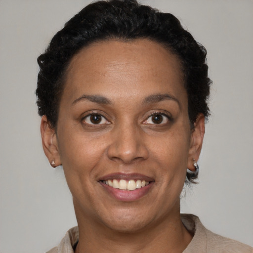 Joyful black adult female with short  brown hair and brown eyes