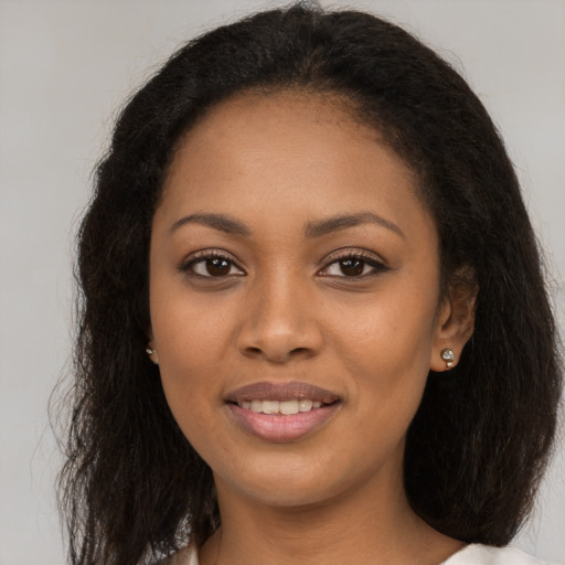 Joyful black young-adult female with long  brown hair and brown eyes