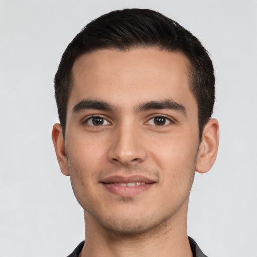 Joyful white young-adult male with short  black hair and brown eyes