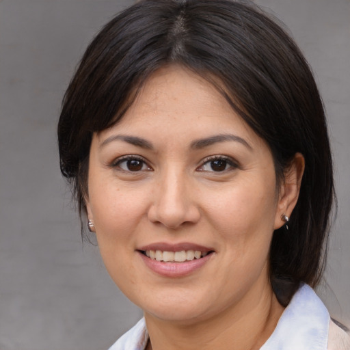 Joyful asian adult female with medium  brown hair and brown eyes
