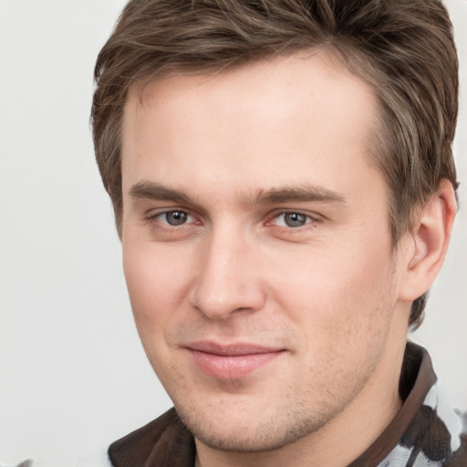 Joyful white young-adult male with short  brown hair and grey eyes