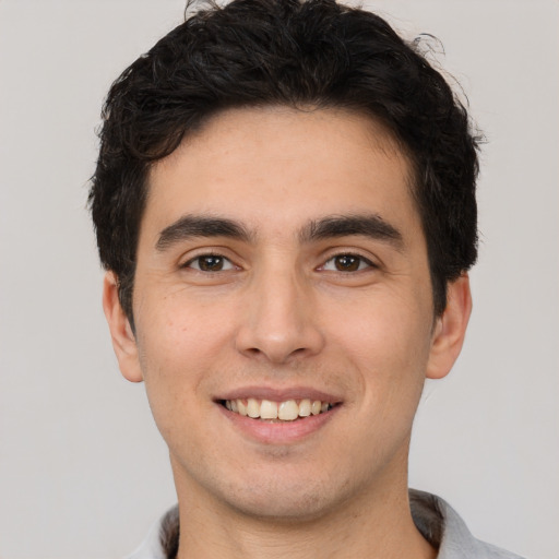 Joyful white young-adult male with short  black hair and brown eyes