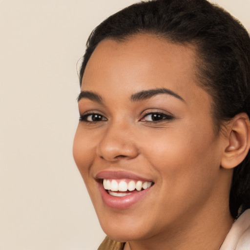 Joyful latino young-adult female with long  brown hair and brown eyes