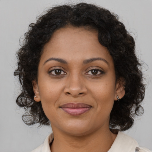 Joyful black young-adult female with medium  brown hair and brown eyes