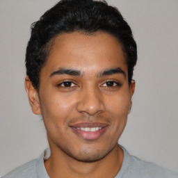 Joyful latino young-adult male with short  black hair and brown eyes