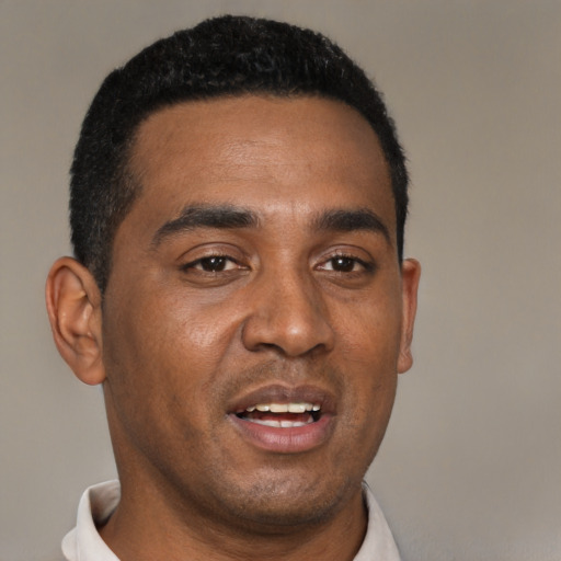 Joyful black young-adult male with short  black hair and brown eyes
