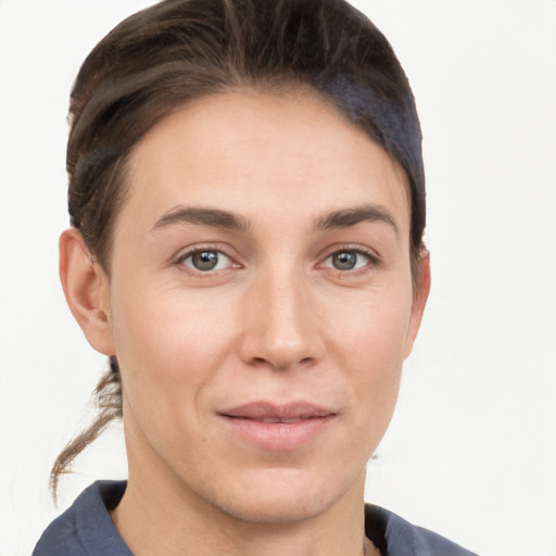 Joyful white young-adult female with medium  brown hair and grey eyes