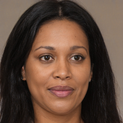 Joyful black adult female with long  brown hair and brown eyes