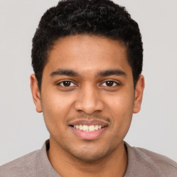 Joyful latino young-adult male with short  brown hair and brown eyes