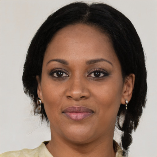 Joyful black adult female with medium  black hair and brown eyes