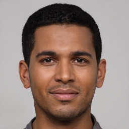 Joyful black young-adult male with short  black hair and brown eyes