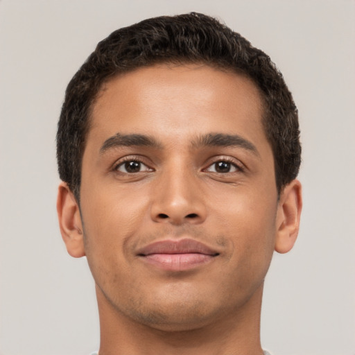 Joyful latino young-adult male with short  brown hair and brown eyes