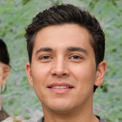 Joyful white young-adult male with short  black hair and brown eyes