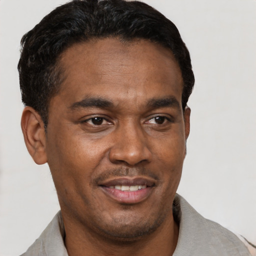 Joyful latino young-adult male with short  brown hair and brown eyes